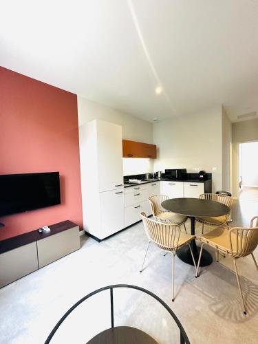 un salon avec une table et des chaises et une cuisine dans l'établissement R'Apparts 2-Room Colonel Urbain, à Grenoble