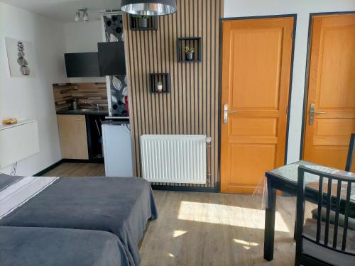 a small room with a bed and a kitchen at Cléome in Arques-la-Bataille