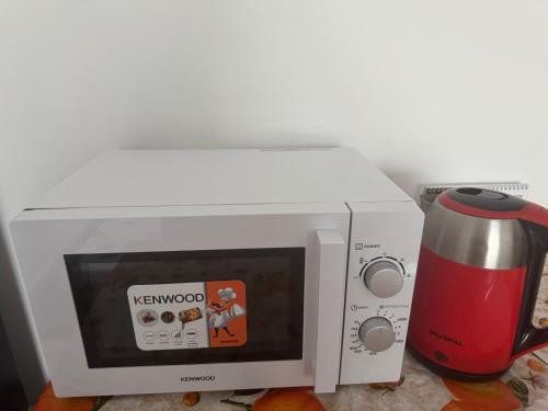 a microwave oven with a coffee pot next to it at Homestay Cozy bedroom with private attached washroom in ajman villa in Ajman