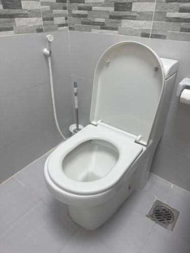a bathroom with a white toilet in a stall at Homestay Cozy bedroom with private attached washroom in ajman villa in Ajman