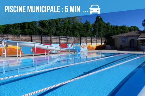 une grande piscine avec un toboggan aquatique dans l'établissement Suite indépendante - Le Coquelicot, à Peyruis