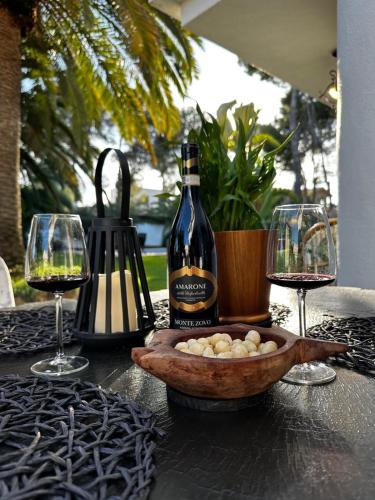 a bottle of wine and two glasses on a table at Villa DEA - Home away from home - Families Only in Salou