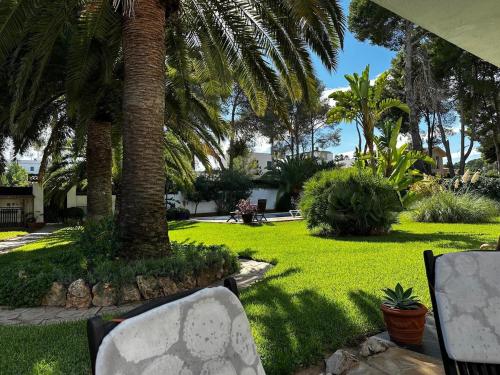 a park with palm trees and a lawn with chairs at Villa DEA - Home away from home - Families Only in Salou