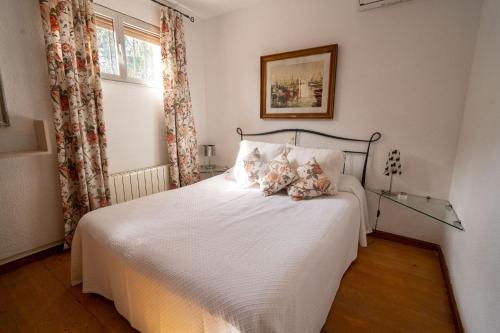 a bedroom with a bed with white sheets and a window at Villa DEA - Home away from home - Families Only in Salou
