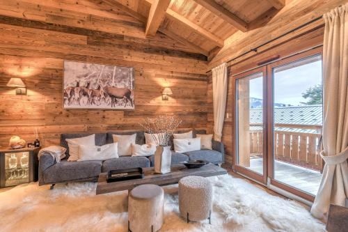 un salon avec un canapé et une grande fenêtre dans l'établissement Appartement Mady - Welkeys, à Megève