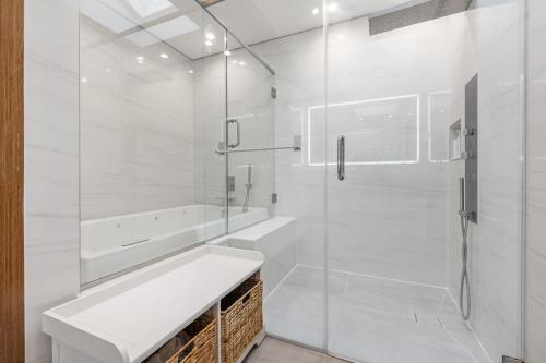 une salle de bain blanche avec lavabo et douche dans l'établissement Luxury 5BR Smart Home Near JFK with Gym, Theater & BBQ, à Valley Stream