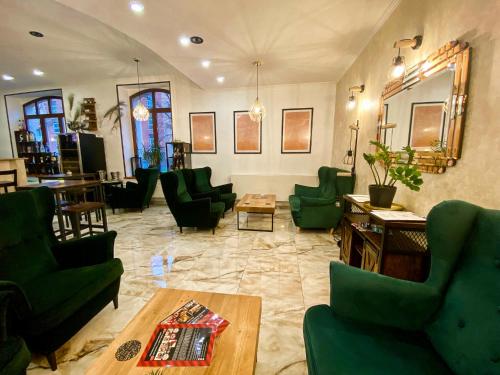 a living room with green chairs and a table at Wellness Hotel Beethoven in Chomutov
