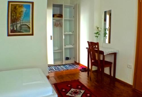 a room with a bed and a table and a chair at Veranda B&B in Berat
