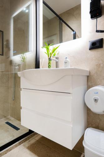 a white bathroom with a sink and a toilet at AL Apartments Tirana in Tirana