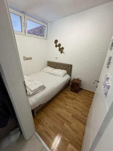 a small bedroom with a bed and a window at Sarajevo Bulevar in Sarajevo