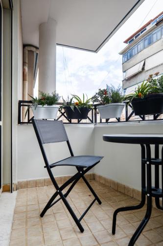 a black chair sitting on a balcony with potted plants at AL Apartments Tirana in Tirana