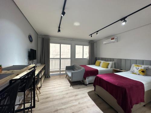 une chambre d'hôtel avec deux lits et un bureau dans l'établissement Rover Centro, à São Paulo