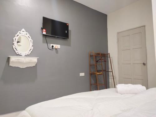 a bedroom with a bed and a tv on the wall at D'Paddy HR Homestay in Arau