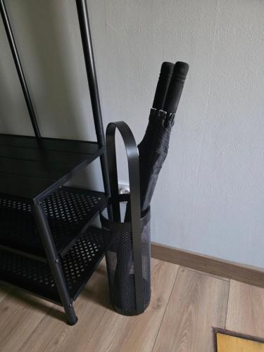 a wine bottle in a black basket on the floor at Maison entière avec espace cinéma in Riom