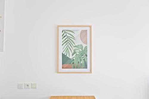 a framed picture of palm trees on a wall at Cozy studio near Paris & Orly in Vigneux-sur-Seine