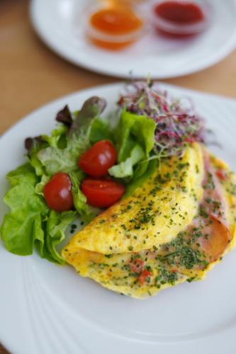 a white plate of food with a salad and fish at Kongress Hotel Davos in Davos