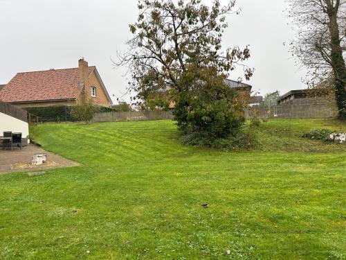 une cour herbeuse avec une maison et un arbre dans l'établissement Appartement Belle Dune, à Bray-Dunes
