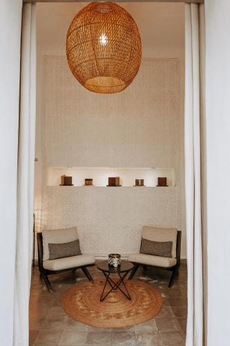 a room with two chairs and a table and a chandelier at Riad Villa Wengé & Spa in Marrakech