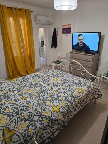 une chambre avec un lit et une télévision à écran plat dans l'établissement Belle maison 2 chambres avec extérieur et Parking couvert, à La Ciotat