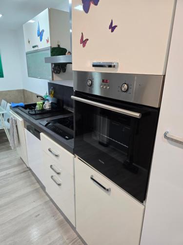 - une cuisine équipée d'un four avec plaques de cuisson en noir et blanc dans l'établissement Belle maison 2 chambres avec extérieur et Parking couvert, à La Ciotat