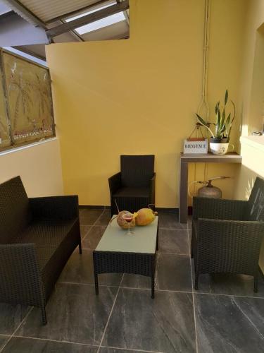 a living room with two chairs and a table at Ti case muguets in Saint-Paul