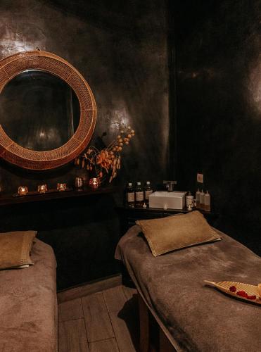 a dark room with two beds and a mirror at Riad Villa Wengé & Spa in Marrakech