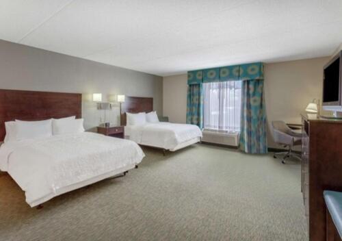 a hotel room with two beds and a desk at Hampton Inn Richmond - South in Richmond