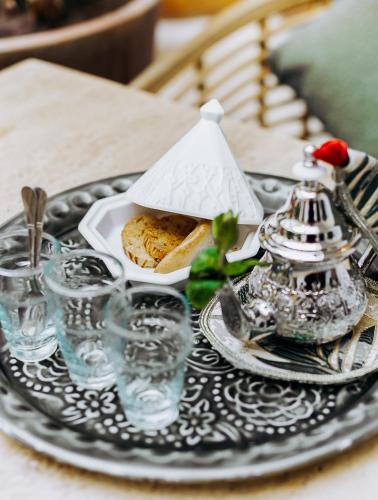 a table with a plate of food and glasses on it at Riad Villa Wengé & Spa in Marrakech