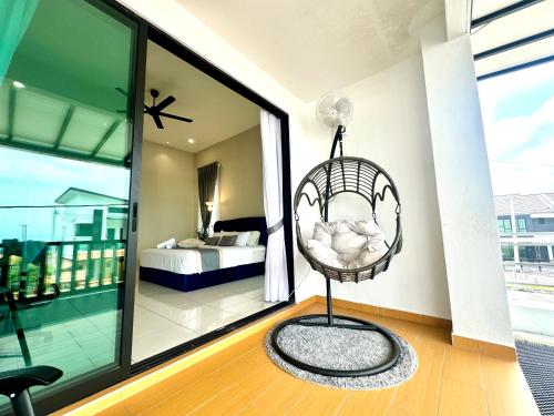 a room with a swinging chair and a bedroom at Ipoh Lahat Mines Private Pool Lake Villa by IWH Suites in Lahat