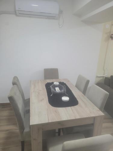 a wooden table with chairs and a laptop on it at Golden Apartment in Valjevo