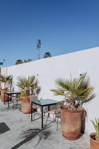 a patio with tables and chairs and potted plants at Riad Villa Wengé & Spa in Marrakech