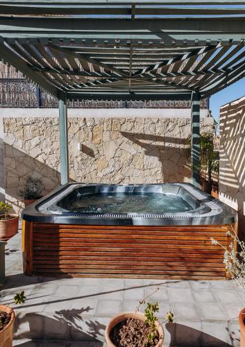 a hot tub on a patio with a stone wall at Riad Villa Wengé & Spa in Marrakech