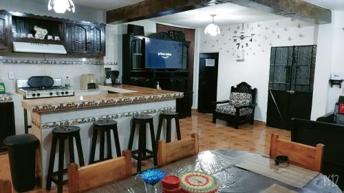 a kitchen with a bar with stools and a table at Terrazas Hotel and Hostel in Taxco de Alarcón