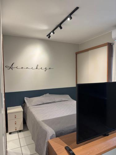 een slaapkamer met een bed en een flatscreen-tv bij Loft moderno e aconchegante próximo ao Aeroporto, Rodoviária Interestatual, P Federal, Casv da Empaixada - Brasília in Brasilia
