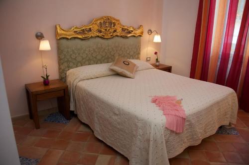 a bedroom with a white bed with a pink dress on it at Villa Lieta in Ischia