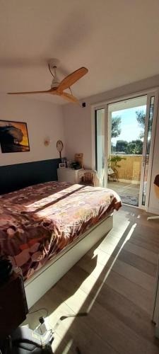 une chambre avec un lit et une porte coulissante en verre dans l'établissement Le Grand Cocon, à La Ciotat