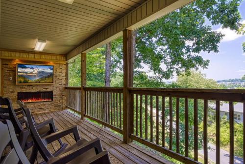 a screened porch with rocking chairs and a fireplace at Inn The Vicinity in Pigeon Forge