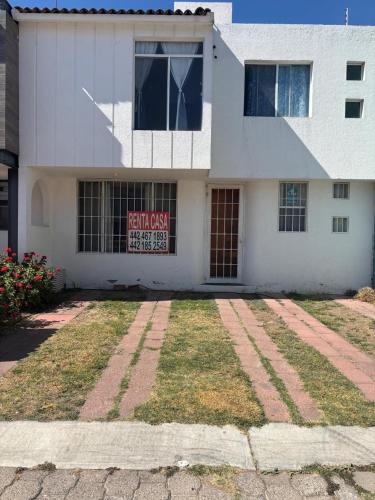 a white house with a sign in the front of it at Fresnos 14 Queretaro in Mendiola