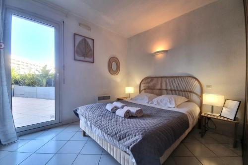 une chambre avec un lit avec deux serviettes dessus dans l'établissement Le Christina - Terrasse - Parking - WIFI, à Saint-Cyprien