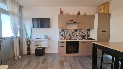 a kitchen with white cabinets and a counter top at Appartement en RDC climatisé avec terrasse ombragée et privative in Le Grau-du-Roi