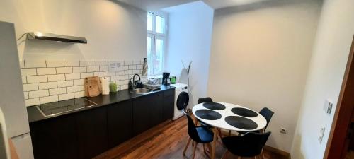 Una pequeña cocina con una mesa y un fregadero. en Stacja Jeżyce, en Poznan