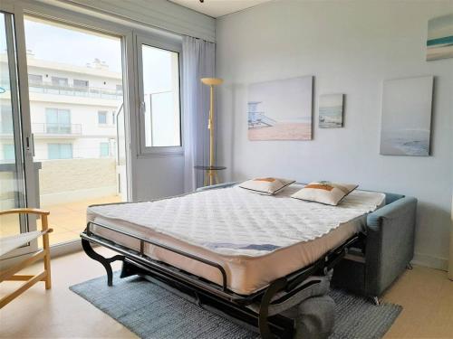 un grand lit dans une chambre avec une grande fenêtre dans l'établissement La Baule, studio avec terrasse à deux pas de la plage ! - FR-1-392-32, à La Baule