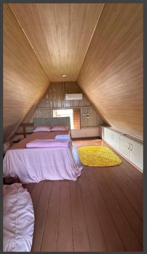 a room with two beds and a wooden floor at Chalé da Lourdes in Santarém