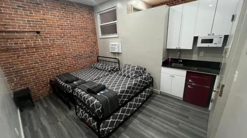 a small room with a bed and a brick wall at 31 Street Broadway Hotel in New York