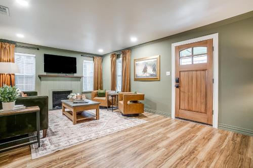 a living room with a television and a door at Fort Worth Cottage l 2 Bed with King & Queen l Walking Distance Will Rogers in Fort Worth