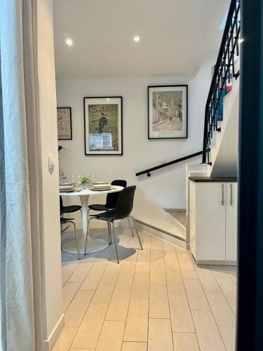 une salle à manger avec une table et des chaises et des escaliers dans l'établissement Maison duplex, 2 chambres, terrasse en rooftop, à Saint-Ouen