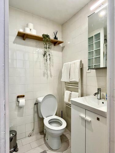 une salle de bain blanche avec des toilettes et un lavabo dans l'établissement Maison duplex, 2 chambres, terrasse en rooftop, à Saint-Ouen