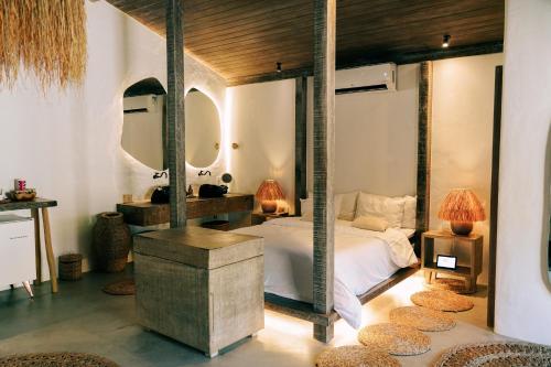 a bedroom with a large bed with two mirrors at Anacardier Privé Hotel in Atins