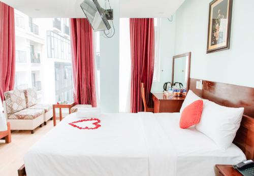 een slaapkamer met een wit bed en rode gordijnen bij Art Deluxe Hotel in Nha Trang