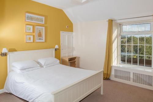 a bedroom with a white bed and a window at Whitton Lodge B&B in Chesterfield